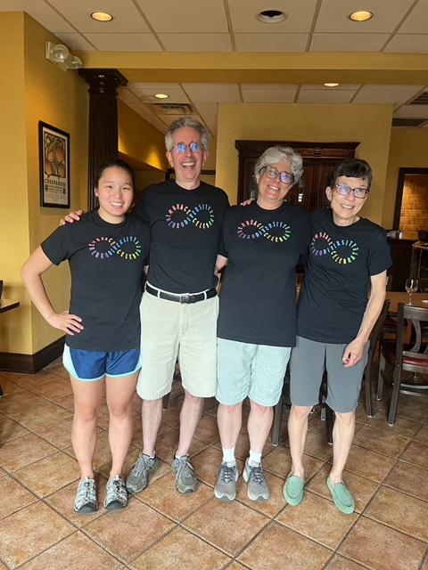 Four people wearing "Embrace/Celebrate Neurodiversity Shirts"